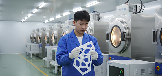 Technician inspecting an SLA master pattern next to industrial vacuum chambers in Jucheng Shenzhen
